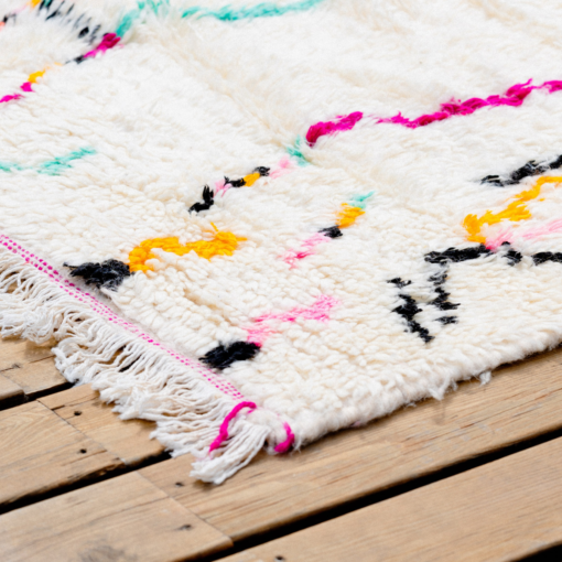 Détail tapis en laine sable, rose, jaune et turquoise