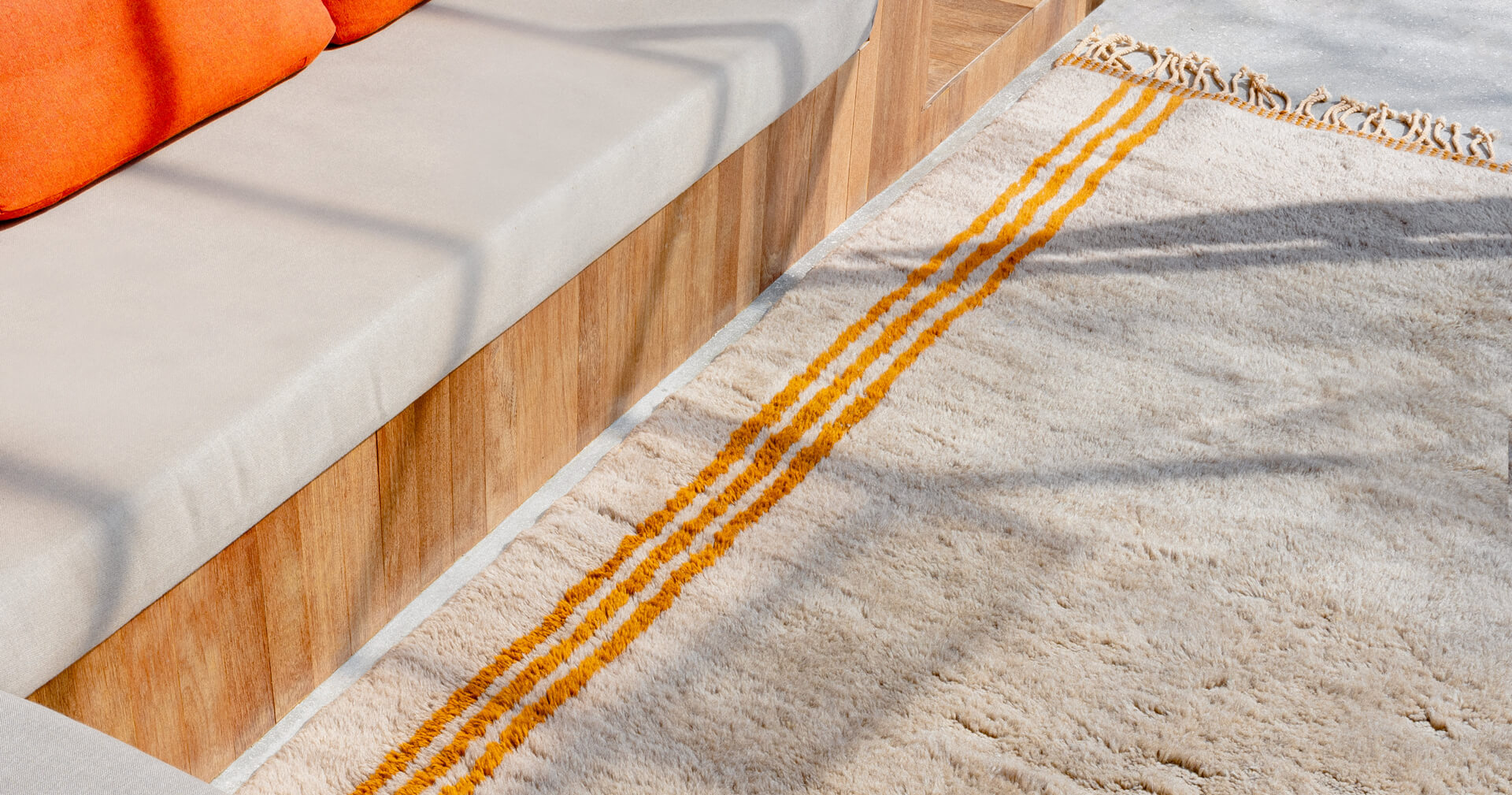 Détail apis en laine salon sable et orange avec franges